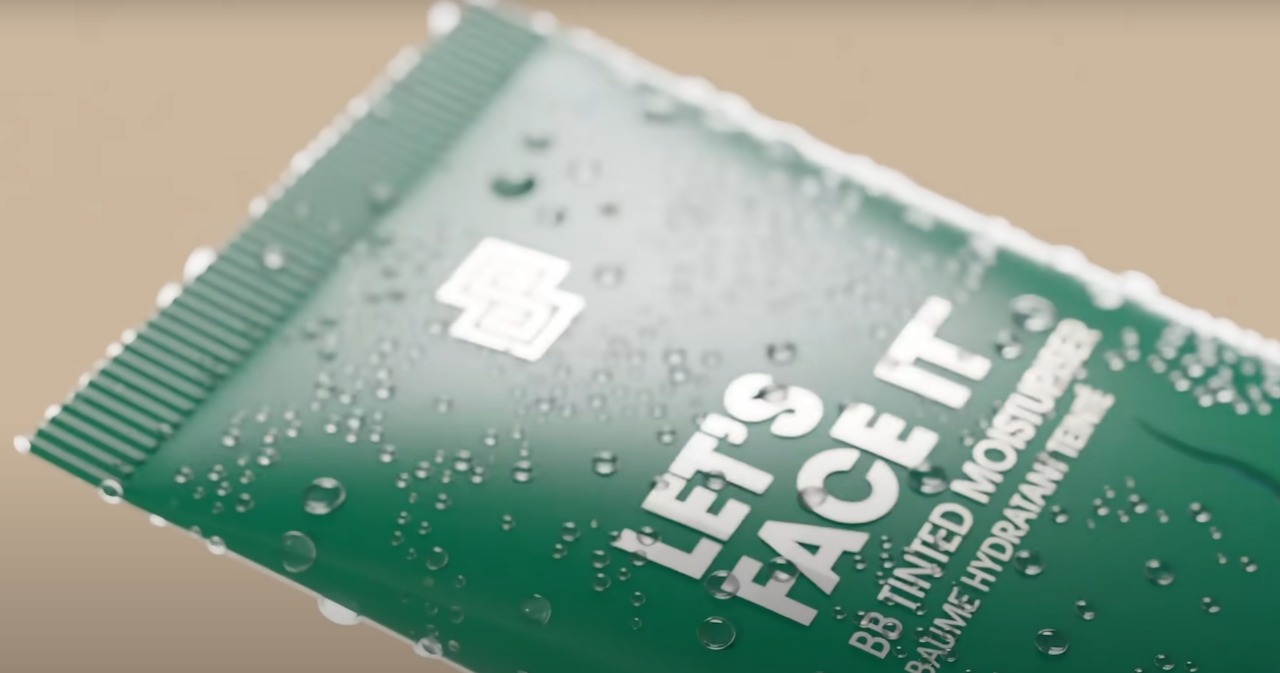 3D render: green BB tinted moisturiser tube with water droplets on a warm backdrop.