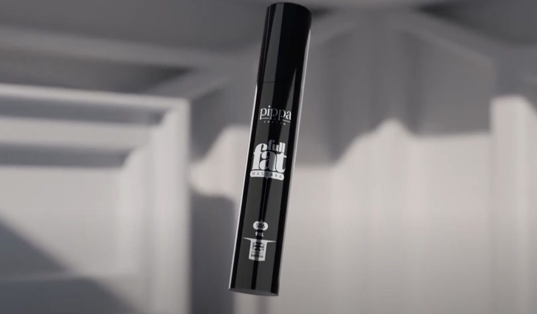 3D render: glossy black mascara tube floating in a soft white interior.