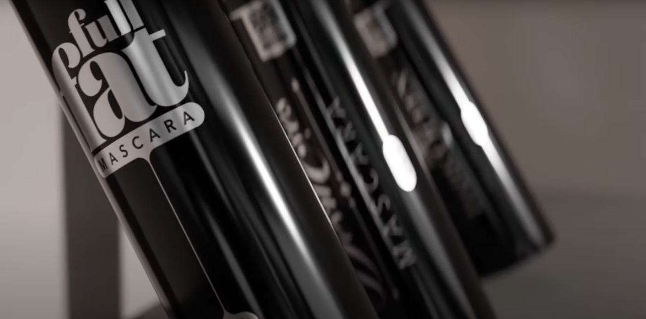 3D render: row of black mascara tubes with chrome typography detail.